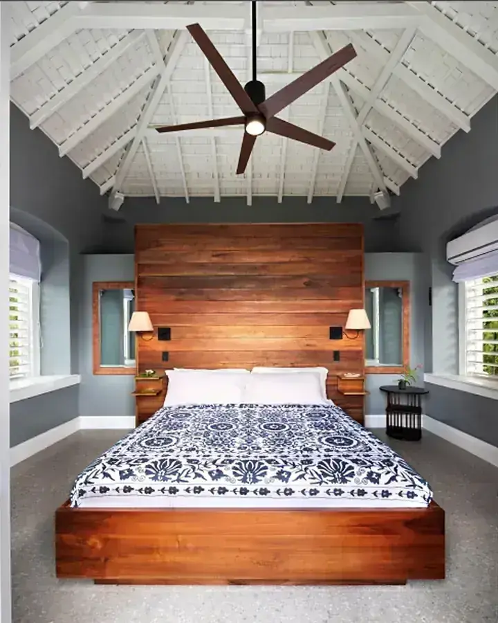 A bedroom with a wooden headboard and ceiling fan